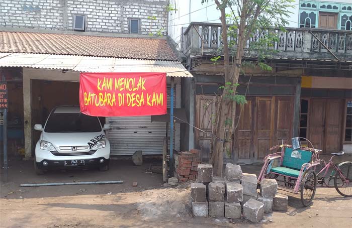 Banner menolak dermaga batu bara di rumah penduduk Kelurahan Kemutran, Kecamatan Gresik Kota. (Foto:anis/ngopibareng)