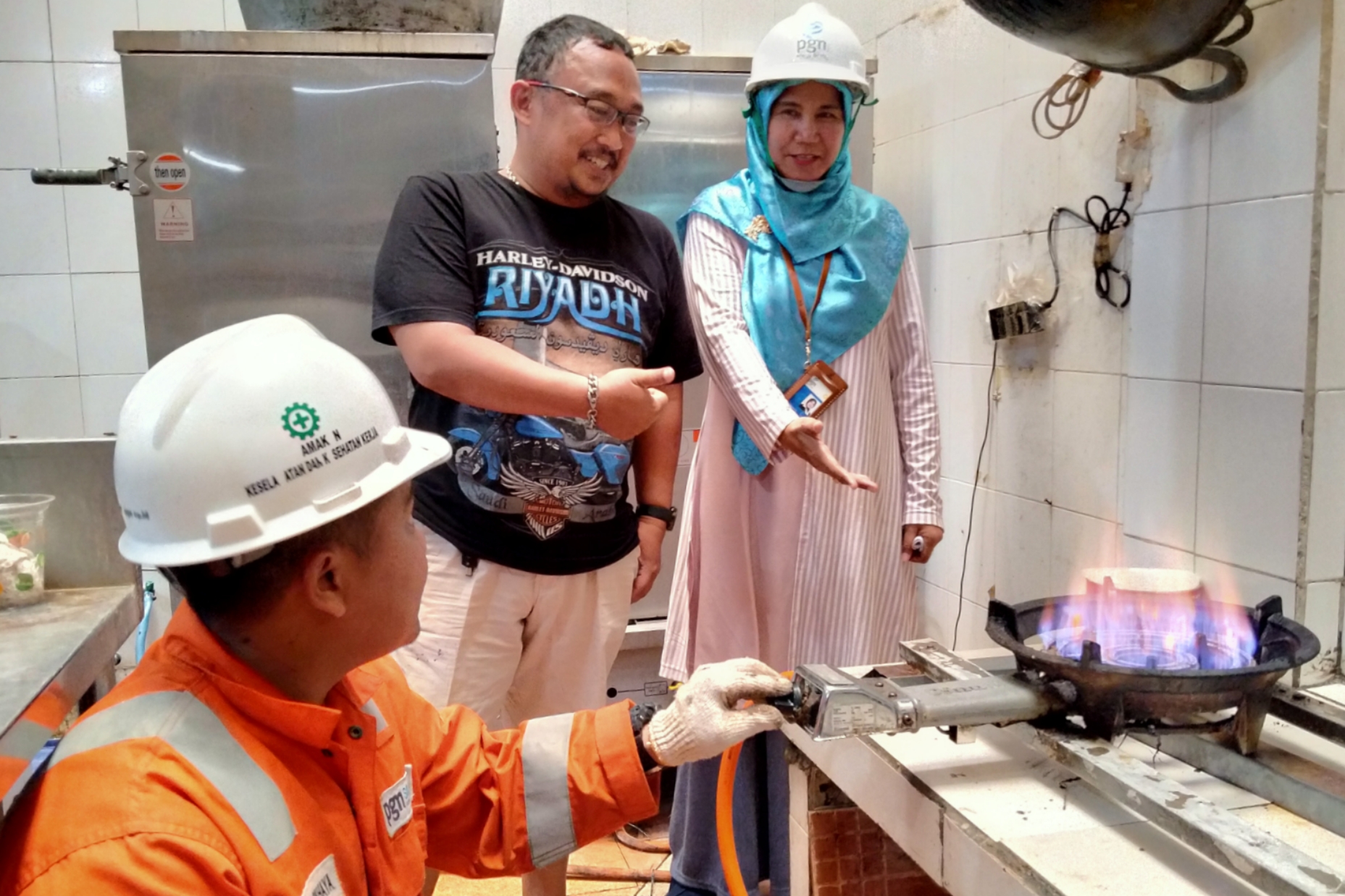 Pengusaha Melati Catering, Tatang Kurniawan (tengah) mendengar penjelasan dari sales representative Jargas PGN Surabaya, Nur Hidayati (kanan) ketika pemasangan Jargas di Jalan Gubeng Kertajaya, Surabaya, Selasa 22 Oktober 2019. (Foto: Fariz/ngopibareng.id) 