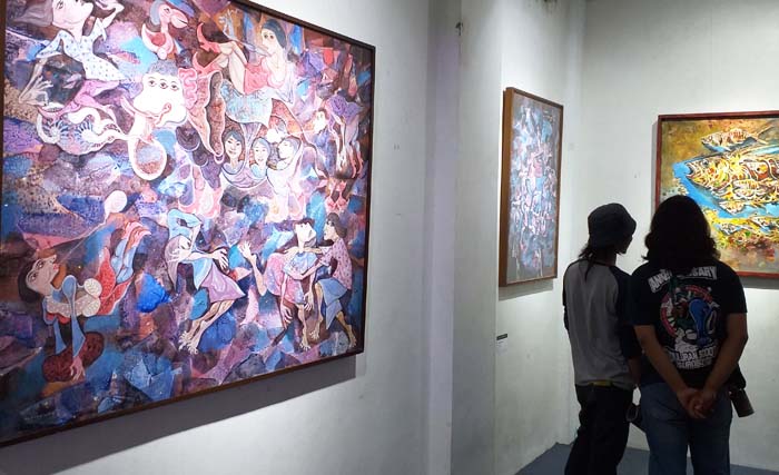 Pengunjung menikmati lukisan yang dipamerkan pada pameran bersama 20 pelukis Jatim di Galeri Prabangkara Jl. Gentengkali Surabaya, Selasa malam. (Foto:Ngopibareng/anis)