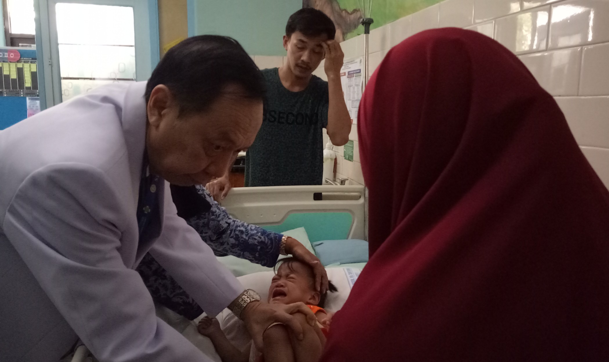 dr.Agus Harianto saat mengajari orang tua Akila dan Azila bagaimana proses mengejan yang baik. (Foto: Pita/Ngopibareng.id)