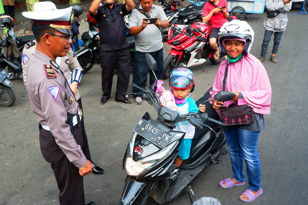 PENGENDARA bersama anaknya mendapatkan boneka saat Operasi Zebra 2019 di Kota Probolinggo. (Foto: Ikhsan/ngopibareng.id)