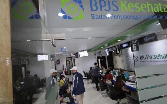 Kantor BPJS, beberapa staf  sedang memberikan layanan kepada peserta. 