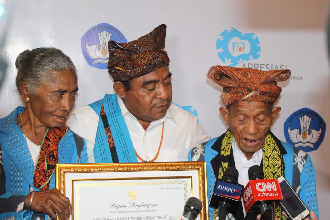 Yakobus Manue Fernandez dan  Margaretha Hati Manhitu, pasangan suami istri asal Timor Tengah Utara Provinsi NTT, dinobatkan sebagai orang tua hebat. Di tengah, anak kandungnya Bupat Timor Tengah Utara  Raymundus Sau Fernande. (Foto: Asm/ngopibareng.id)