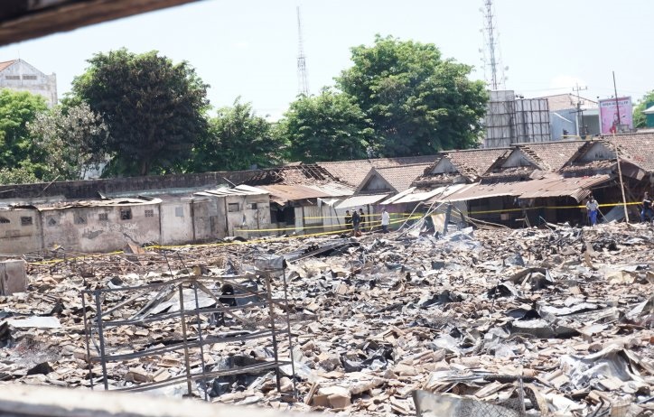 Sejumlah pedagang nekat menerobos garis polisi untuk melihat kios miliknya yang hangus terbakar menyisakan puing kehancuran di dalam kompleks Pasar Ngunut, Tulungagung, Jawa Timur, Sabtu 9 November 2019. (Foto: Antara/Destyan Sujarwoko)