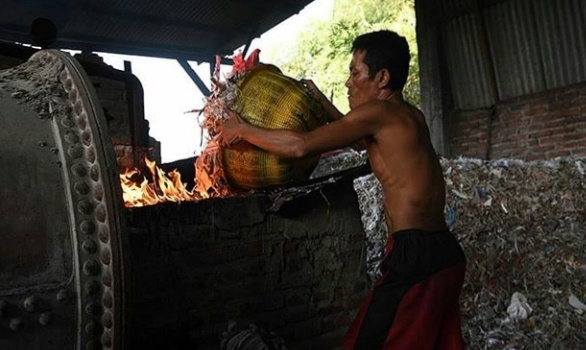 Salah satu karyawan di tempat pembuatan tahu di Tropodo. (Foto: Antara)