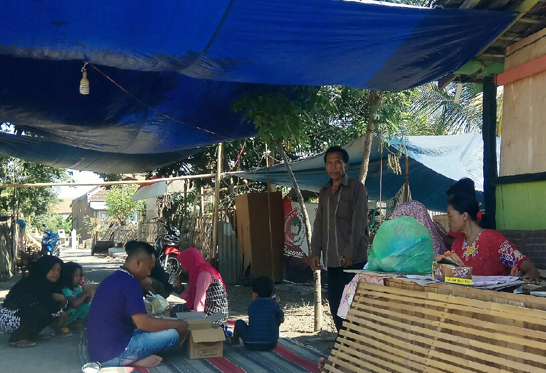 Suamna dan warga yang masih tetap bertahan di sekitar lokasi bekas rumah mereka. (Foto : Hujaini/Ngopibareng.id)