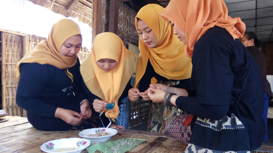 Mahasiswi yang tergabung dalam Barisan Pemuda Adat Nusantara-Osing mempersiapkan salah satu bahan untuk membuat Tumpeng Serakat