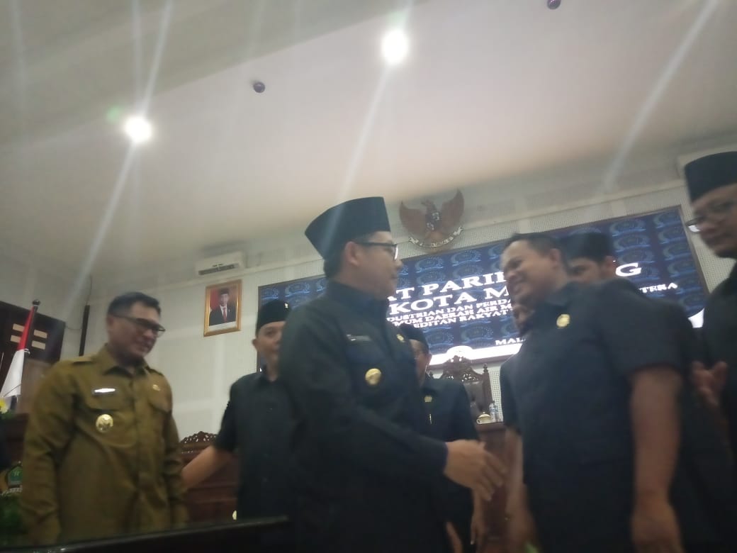 Wali Kota Malang, Sutiaji berjabat tangan dengan Ketua DPRD, Made Rian Diana Kartika, usai mengesahkan Ranperda di Gedung DPRD Kota Malang, Senin 25 November 2019. (Foto: Theo/ngopibareng.id)