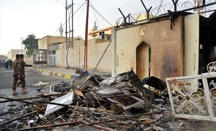 Puing-puing berserakan di depan gedung Konsulat Iran di Najaf, Irak bagian selatan yang dibakar massa Kamis kemarin. (Foto:NBCNews)