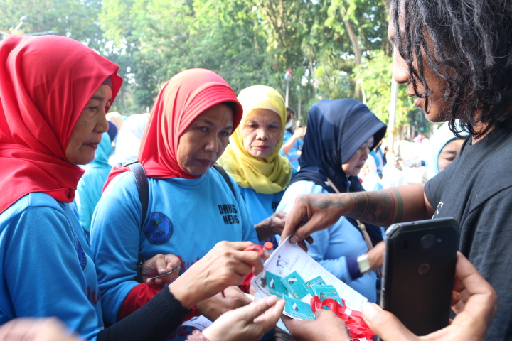 Aktivis legalisasi ganja sedang membagikan selebaran dalam kampanye Hari AIDS Sedunia, 1 Desember 2019 di Car Free Day di Jalan Darmo Surabaya. (Foto: Istimewa)