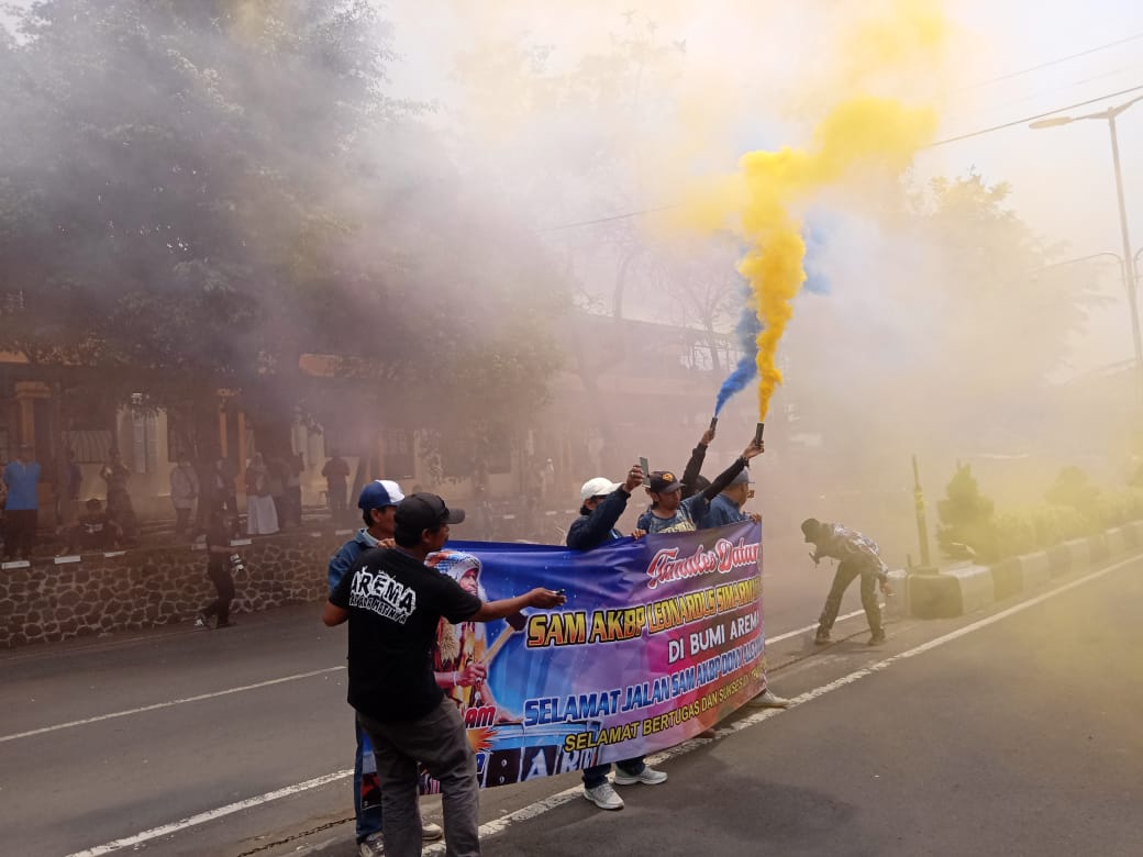 Terlihat para Aremania menyalakan flare usai menyanyikan yel-yel penyambutan Kapolresta Malang Kota yang baru, Leonardus Harapantua Simarmata Permata. (Foto: Theo/Ngopibareng.id)