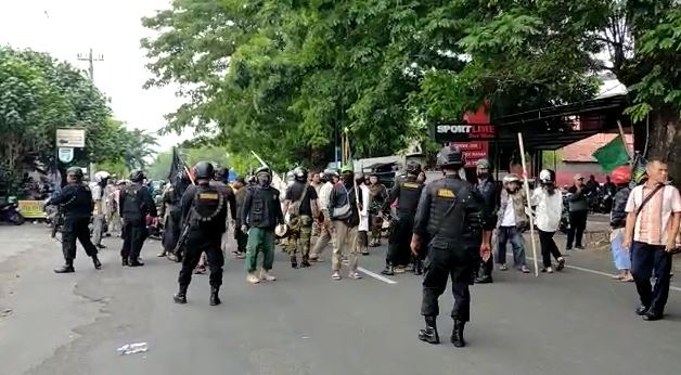 Sekelompok massa yang membawa bendera kalimat tauhit terlibat bentrok di depan Kantor PCNU Solo. (Foto: Istimewa)