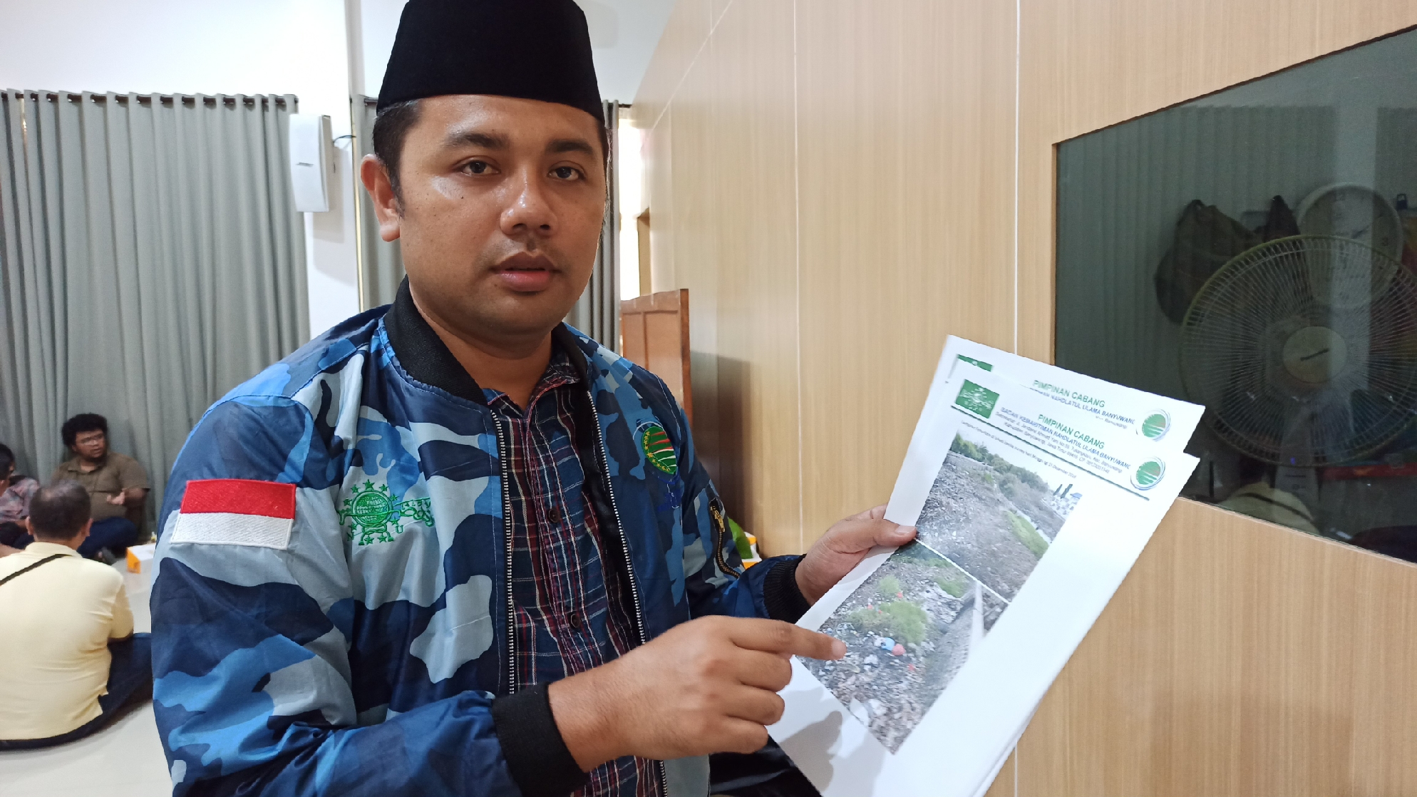 Ikhwan Arief menunjukkan foto di sekitar hutan mangrove yang rencananya akan ditebang. (Foto: Hujaini/ngopibareng.id)