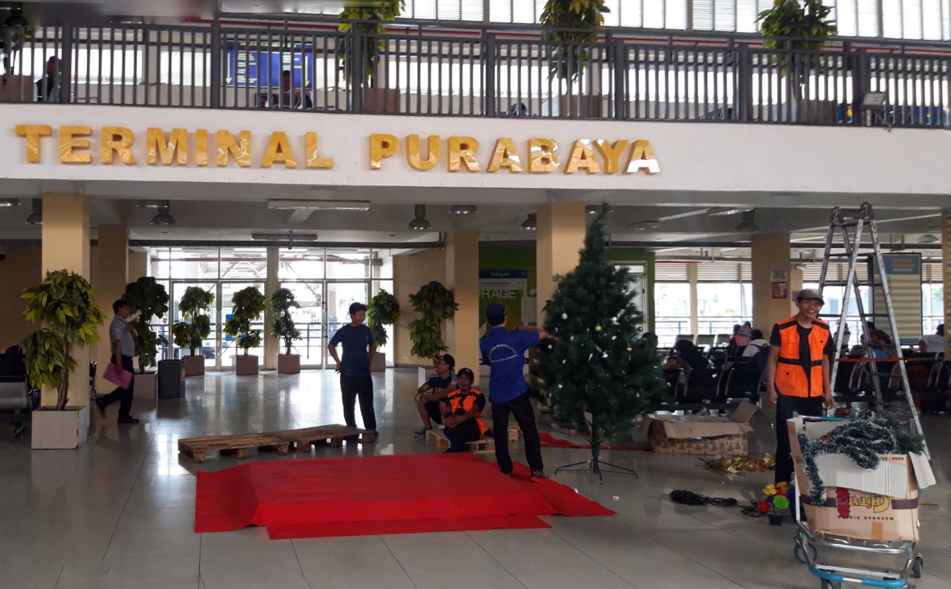 Para pekerja sedang menyiapkan pohon Natal di Terminal Purabaya. Rencananya juga akan ada Santa Claus di terminal ini dalam waktu dekat. (Foto: Haris/ngopibareng.id)