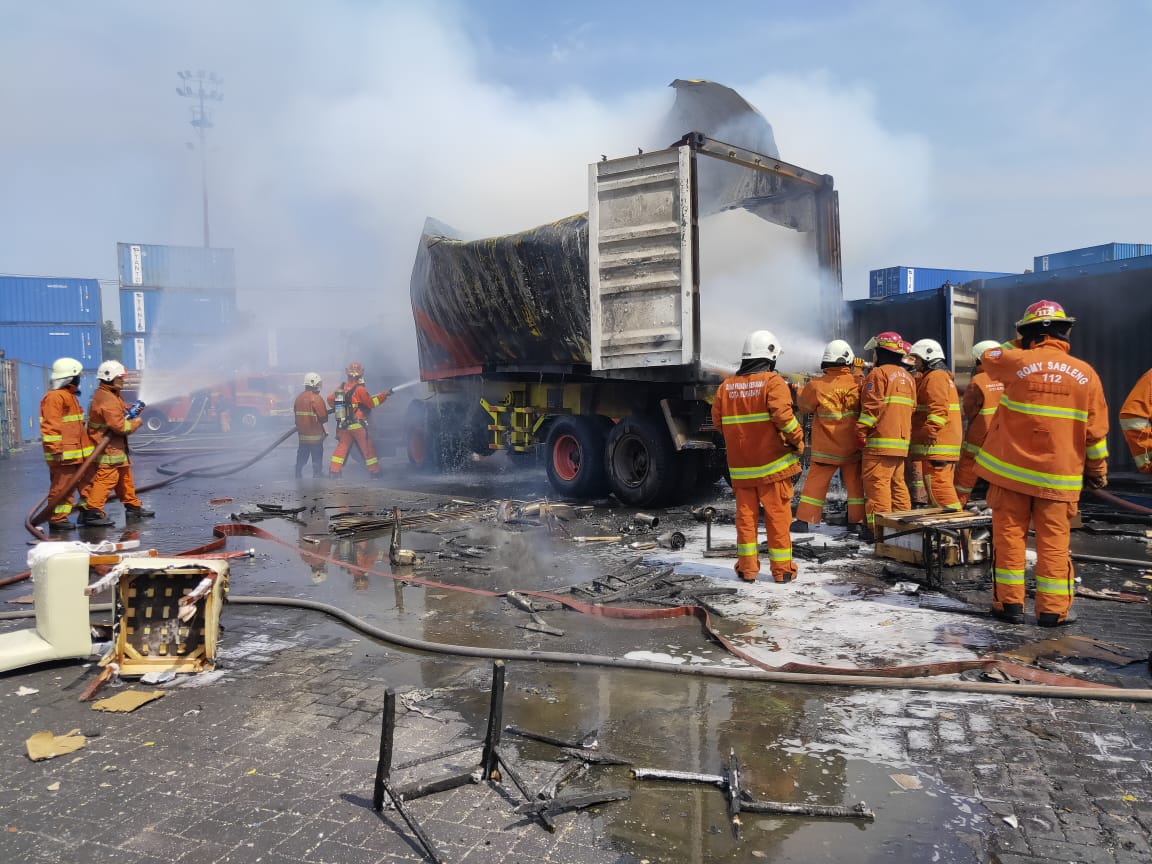 Petugas berusaha memadamkan api yang melahap kontainer pembawa mebel. (Foto: Istimewa)