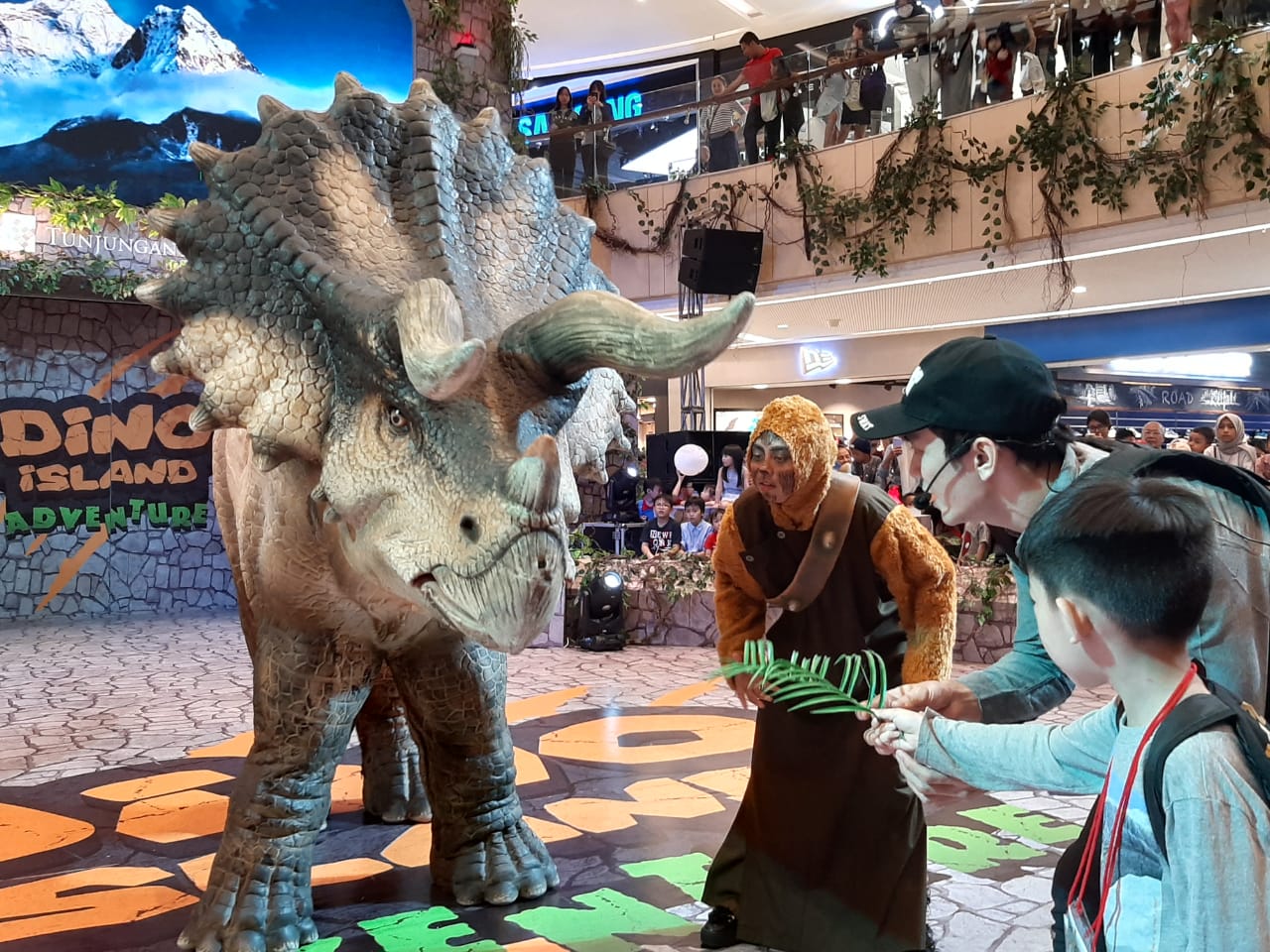 Pengunjung bernama Johny saat berinteraksi langsung dengan Triceratops di Atrium TP 6 Surabaya. (FOTO: Pita/ngopibareng.id)