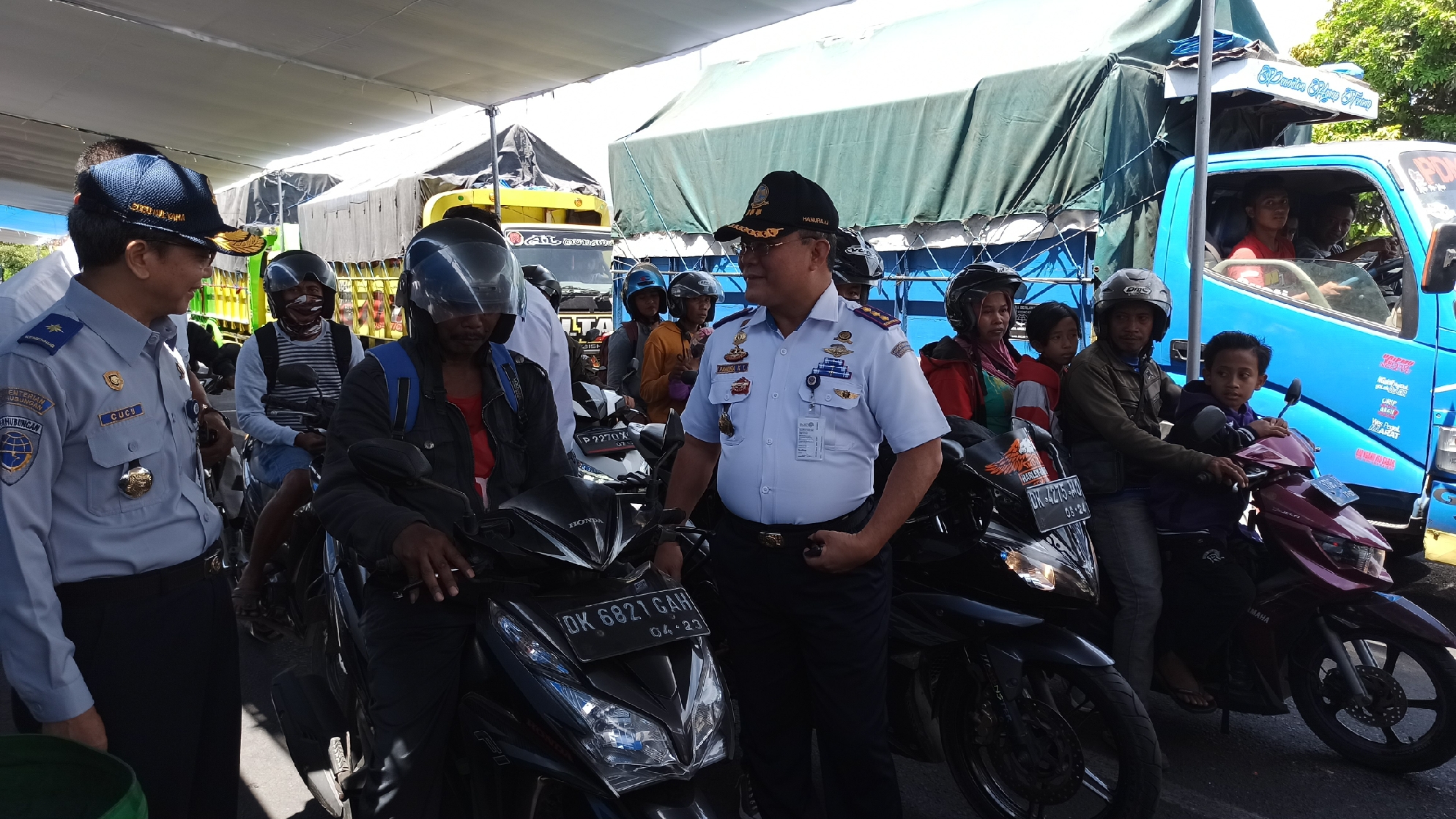 Sekretaris Ditjen Perhubungan Darat Cucu Mulyana (kiri) berbincang dengan pengendara sepeda motor yang antre masuk kapal penyeberangan Pelabuhan Ketapang (foto : Muh Hujaini/ngopibareng.id)