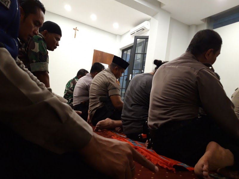 Beberapa aparat kepolisian dan TNI menggelar salat berjamaah di Gereja Paroki Hati Kudus Yesus, Katedral, Surabaya, Selasa 24 Desember 2019. (Foto: Haris/ngopibareng.id)