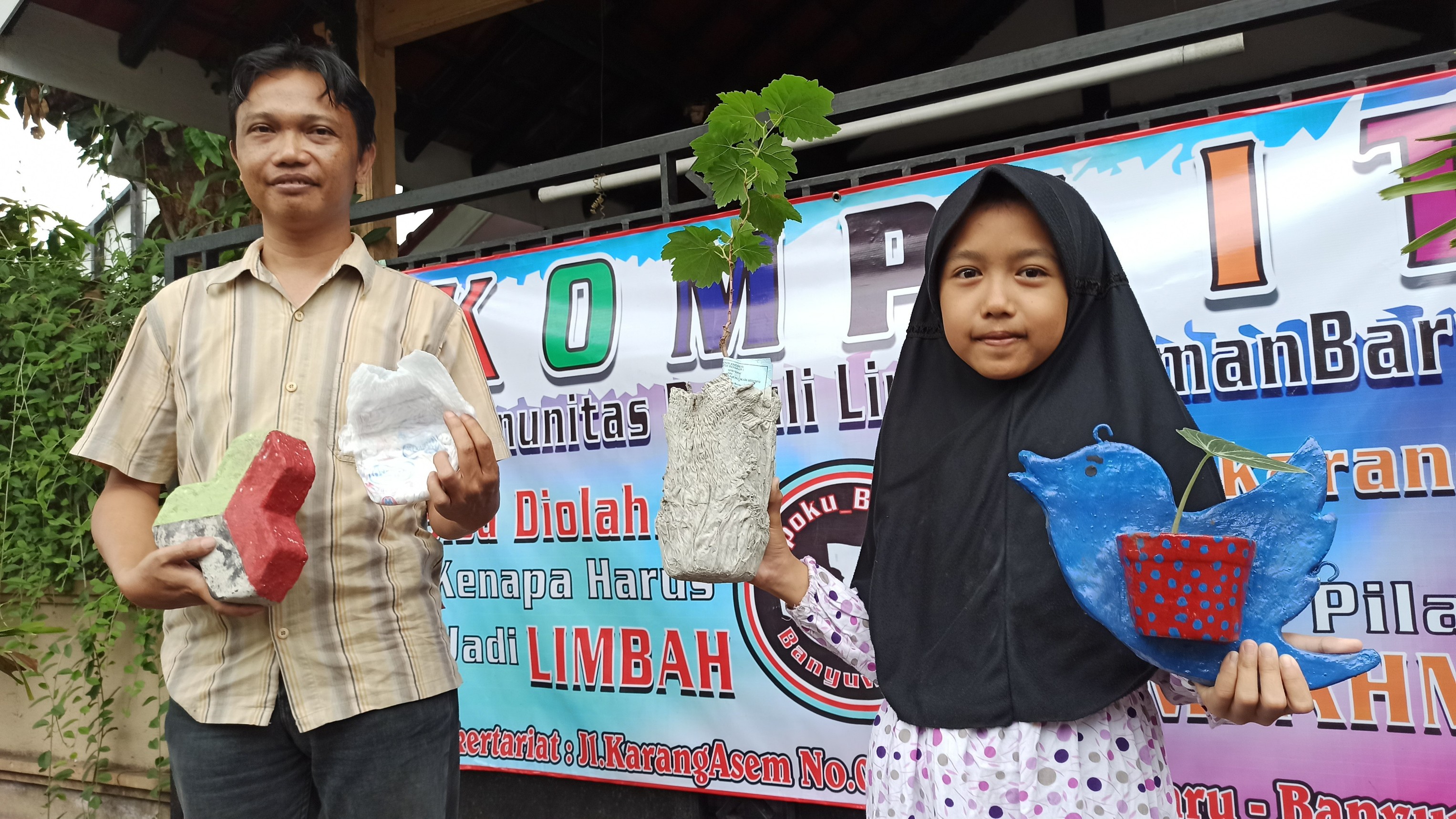 Choirul Anwar bersama putrinya menunjukkan vas bunga, pot bunga, dan paving blok yang terbuat dari popok bayi bekas. (Foto: Hujaini/ngopibareng.id)