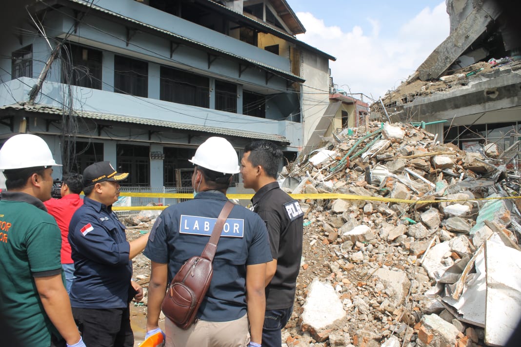 Petugas Puslabfor Bareskrim Polri, belum bisa masuk ke dalam karena k9ndisi gedung labil. (Foto: Asmanu/ngopibareng.id)