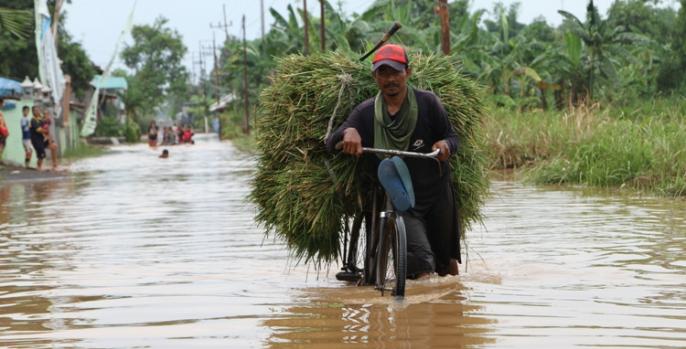 Seorang warga melewati genangan air setelah banjir yang melanda Pasuruan, Selasa, 7 Januari 2020 malam. (Foto: Dok Humas)