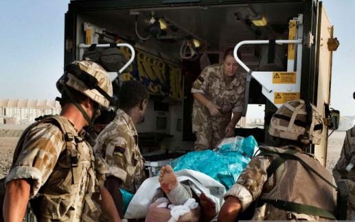 Tentara Inggris  membawa seorang tentara nasional Afghanistan Sersan Quem Abdulh ke dalam sebuah ambulan pada 11 Juni 2007. (Foto:Getty Image/Marco di Lauro)