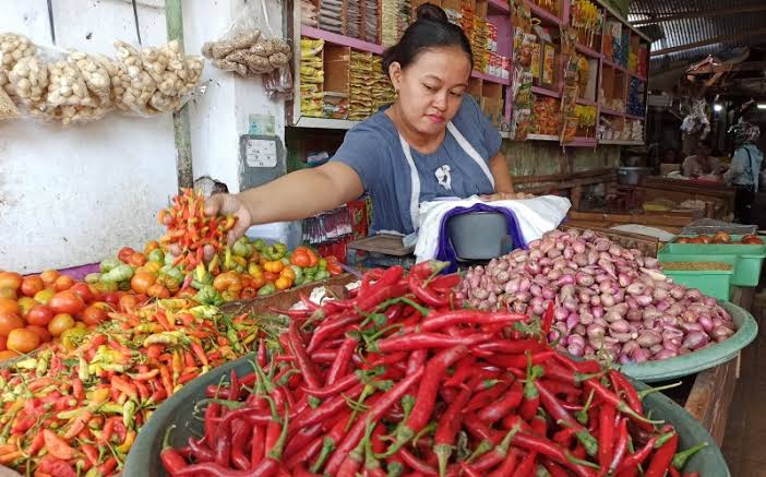 Pedagang Pasar Banyuwangi sedang menata cabe rawit pada bidaknya di Pasar Induk Banyuwangi (foto : Hujaini/ngopibareng.id)