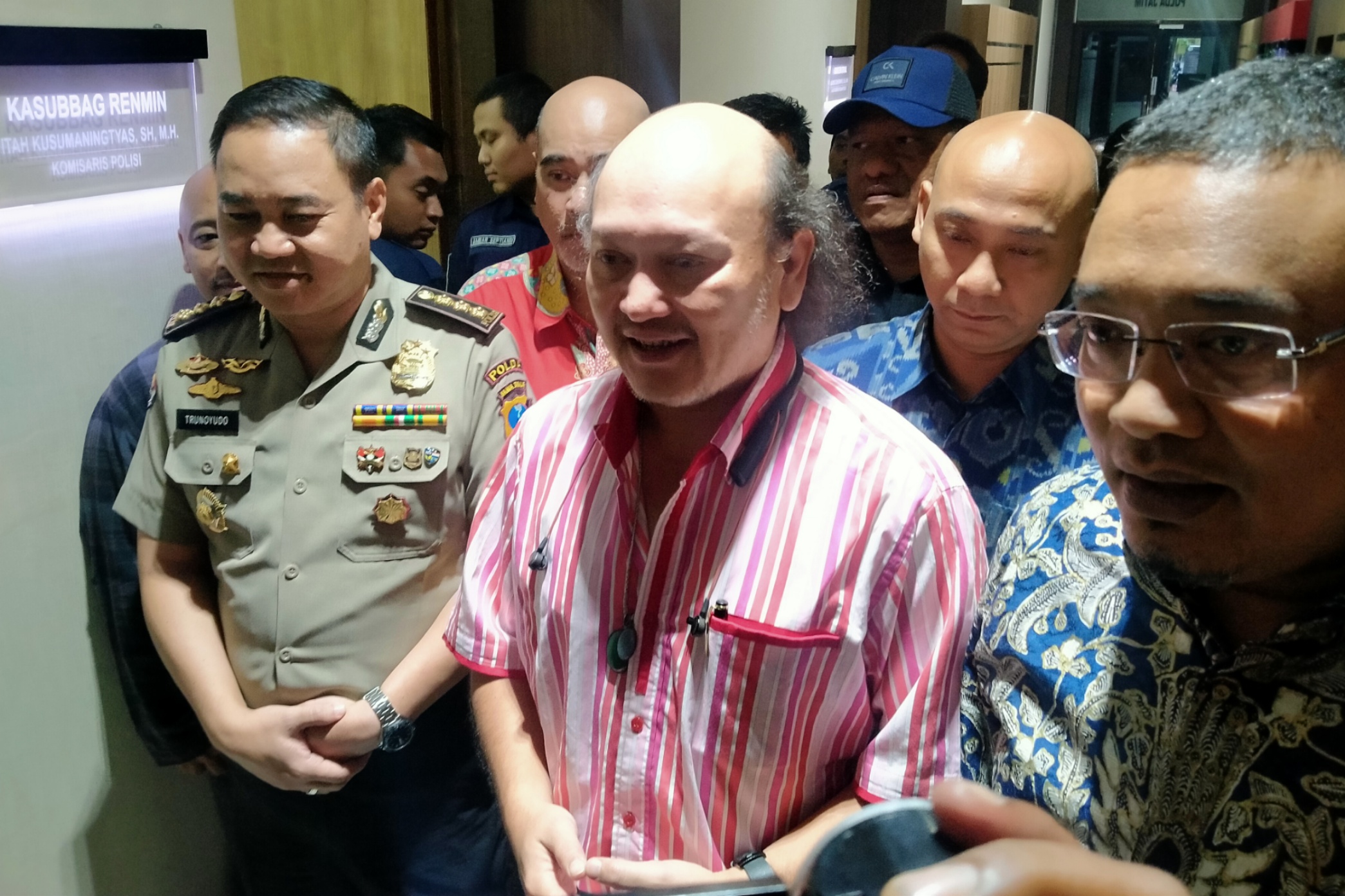 Ari Haryo Wibowo Hardjojudanto (tengah), usai diperiksa penyidik Ditreskrimsus Polda Jatim terkait kasus investasi bodong MeMiles. (Foto: Fariz/ngopibareng.id)