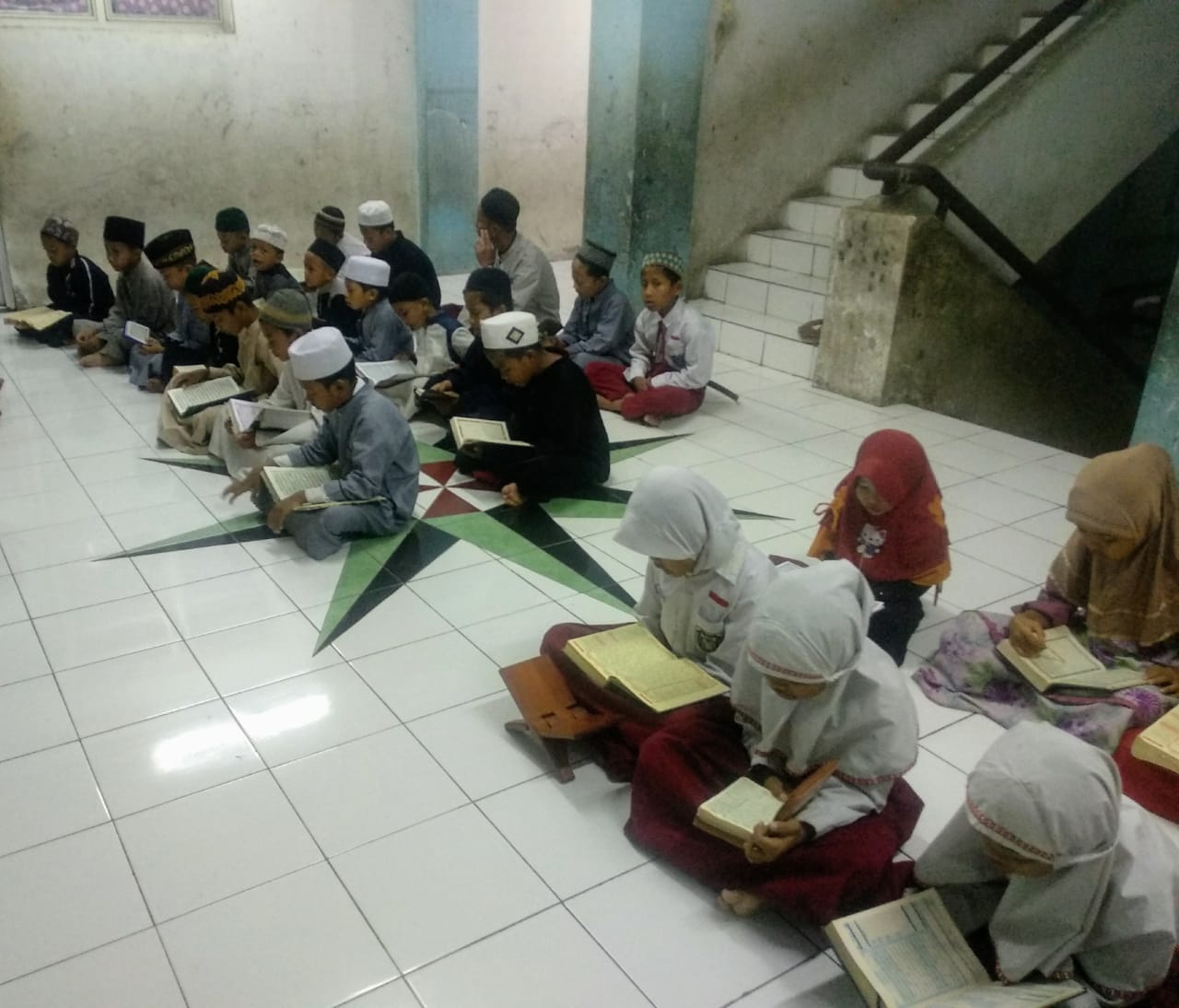 Anak-anak pengungsi Syiah membaca Al-Quran pada Rabu 22 Januari 2020 pagi. Bertempat di ruang terbuka lantai 3 rusun Puspa Agro. (Foto: Rizki Mutqiyyah/ngopibareng.id)