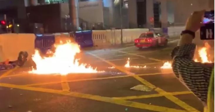 Api di permukaan jalan terlihat setelah pengunjuk rasa melempar sebuah bom molotov ke arah markas pusat polisi Wan Chai di Hong Kong, China, Senin 5 Agustus 2019, dalam gambar video yang didapatkan dari media sosial. Video diambil tanggal 5 Agustus 2019. CAMPUS TV, HKUSU/via REUTERS/aww/cfo (CAMPUS TV, HKUSU via REUTERS/CAMPUS TV, HKUSU)