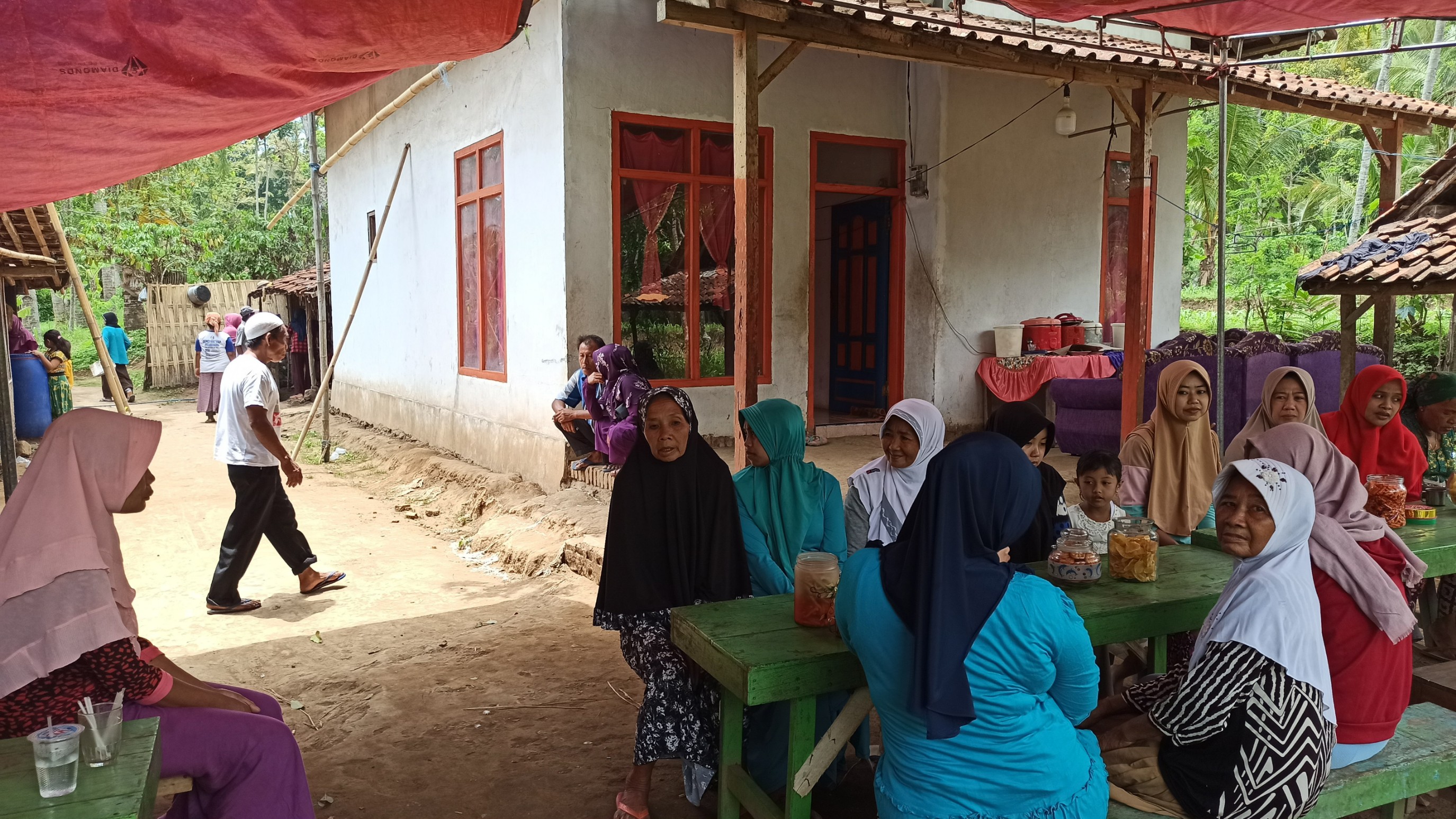 Susiama (kiri) sedang berbincang dengan para pelayat yang datang ke rumahnya (foto : Hujaini/ngopibareng.id)