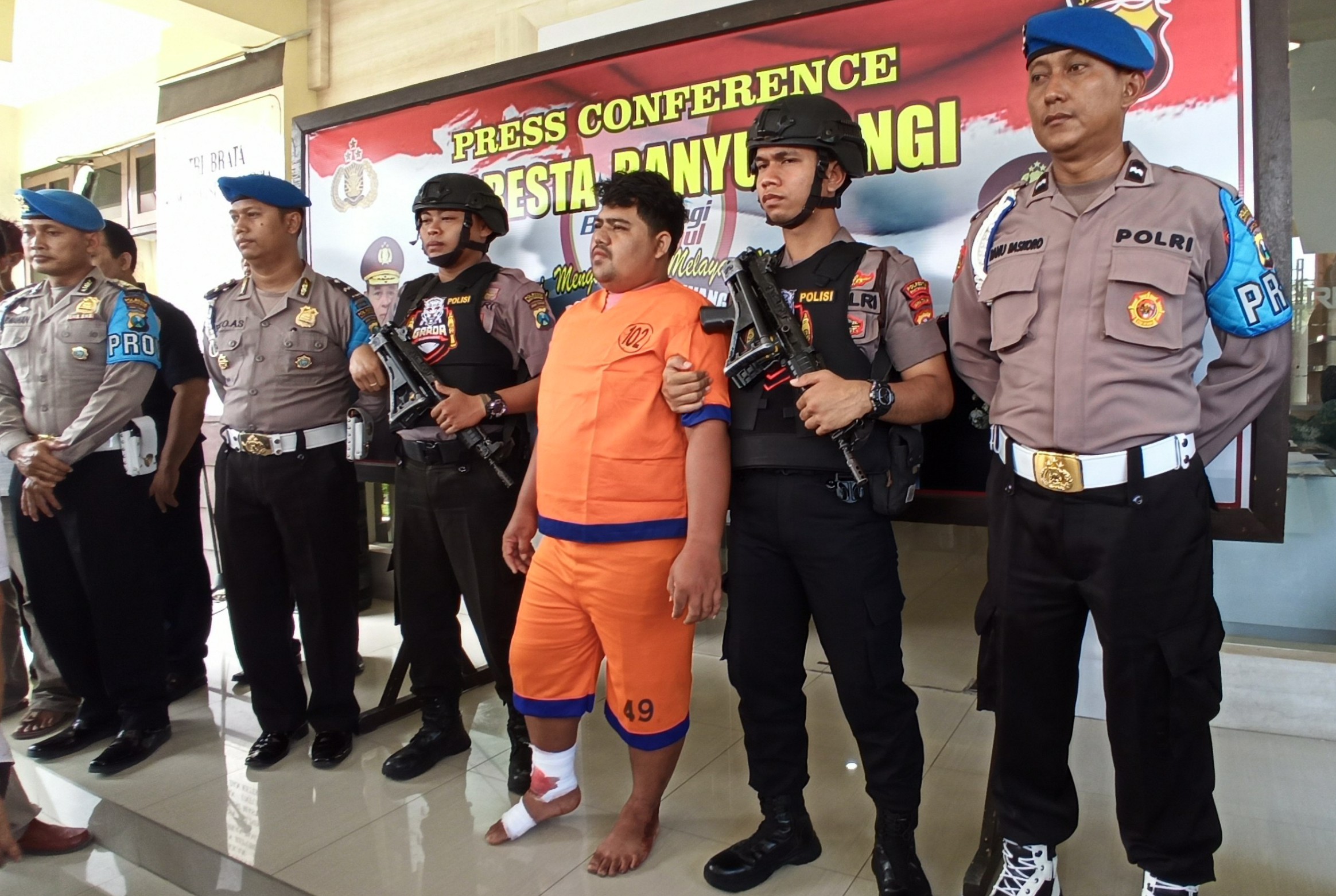 Tersangka pembunuh Rosidah dikawal anggota Polres Banyuwangi. (Foto: Hujaini/ngopibareng.id)