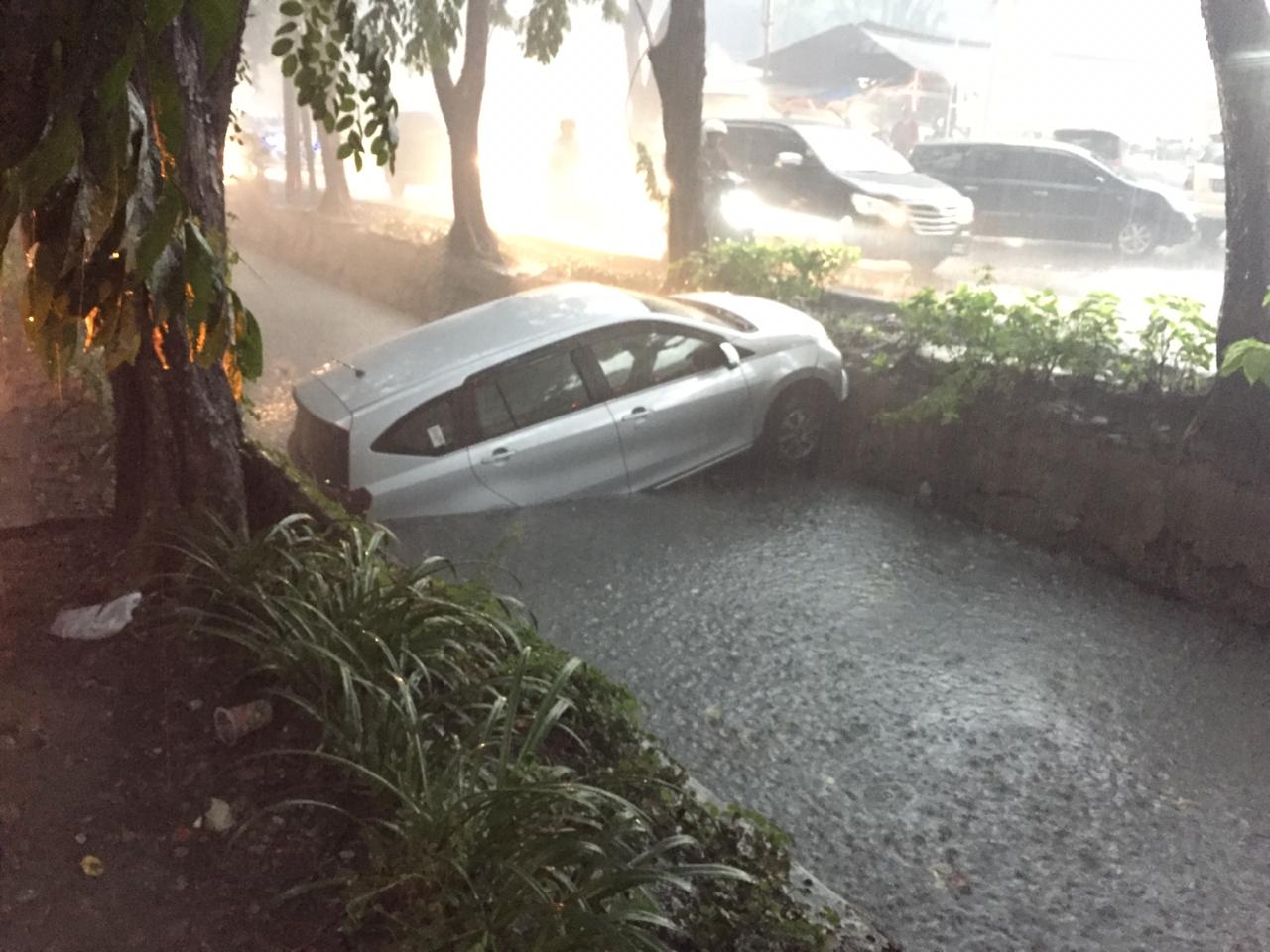 Satu unit mobil nyemplung di kali Injoko atau Jalan Gayung Kebonsari, Surabaya. (Foto: WA Info Kedaruratan 112)