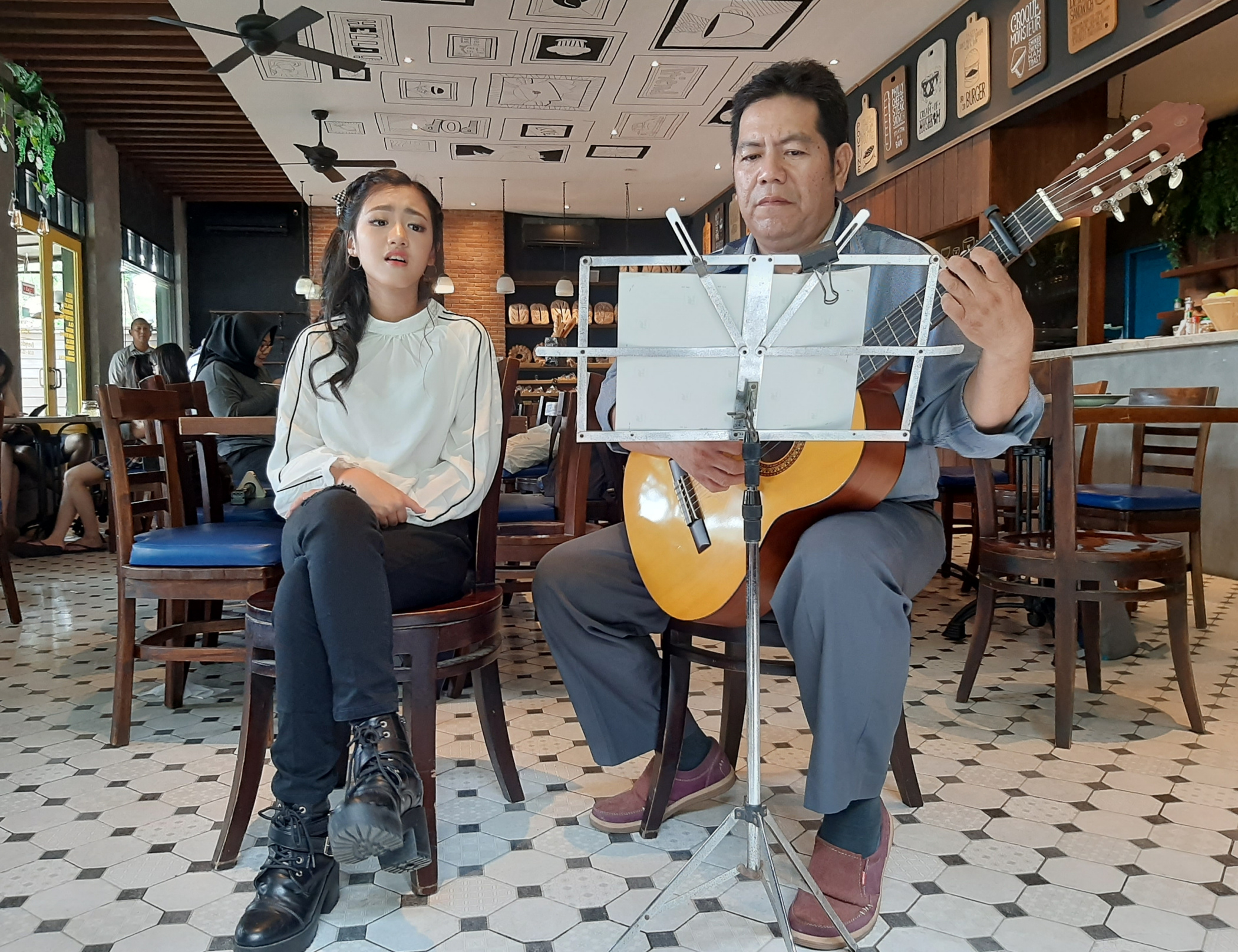 Valerie Utomo (kiri) saat menyanyi diiringi petikan gitar. (Foto: Pita/ngopibareng.id)