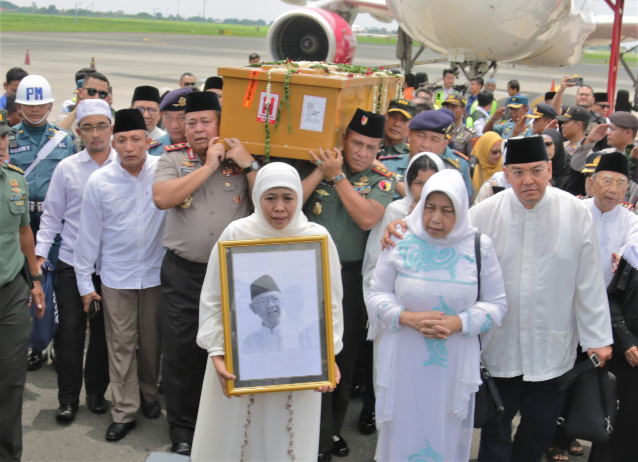 Gubernur Jatim, Khofifah Indar Parawansa bersama Forkopimda Jatim dan keluarga besar Gus Sholah membawa jenazah Gus Sholah turun dari pesawat ke ambulance di Bandara Internasional Juanda, Sidoarjo, Senin 3 Februari 2020. (Foto: Fariz/ngopibareng.id)