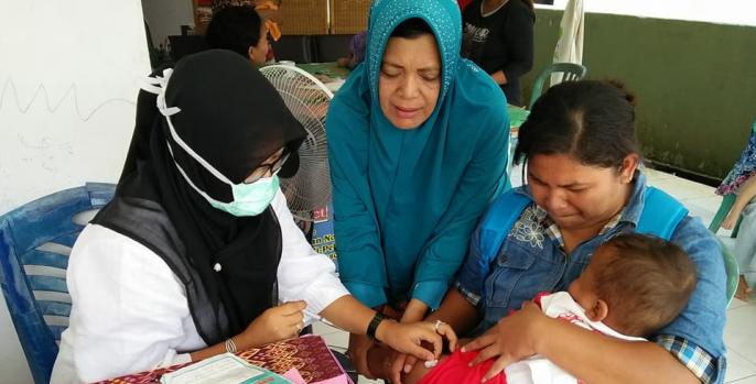 Seorang ibu membawa anaknya ke posyandu untuk penimbangan rutin. (Foto: Dok Humas)