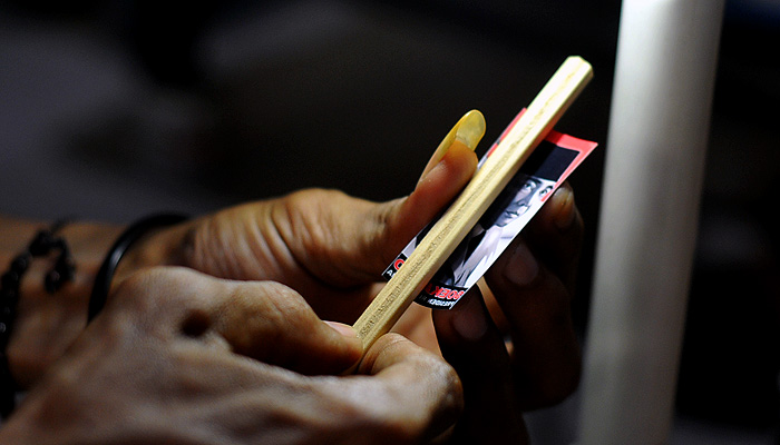 Proses penempelan gambar pada pensil kayu. (foto : Erfan Hazransyah/ngopibareng.id)