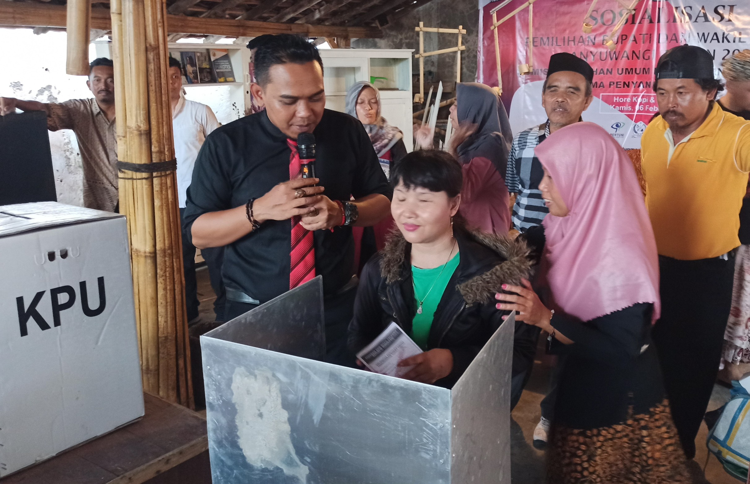 Komisioner Komisi Pemilihan Umum (KPU) Banyuwangi, Dian Purnawan (kiri) mengajari salah satu penyandang disabilitas proses pemungutan suara. (Foto: Hujaini/ngopibareng.id)