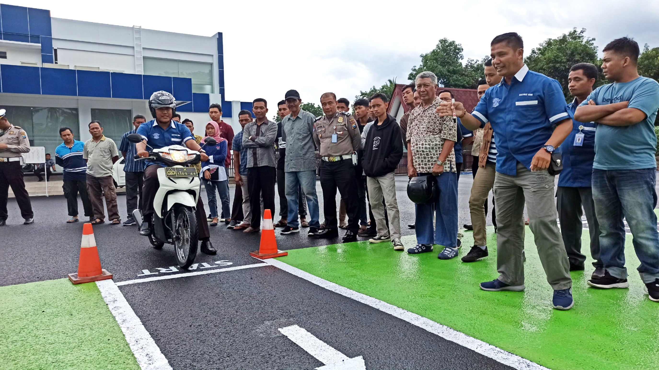 Petugas penguji ujian praktek SIM memberikan penjelasan pada warga yang mengikuti latihan agar lancar menjalani ujian praktek SIM (foto : Hujaini/ngopibareng.id)