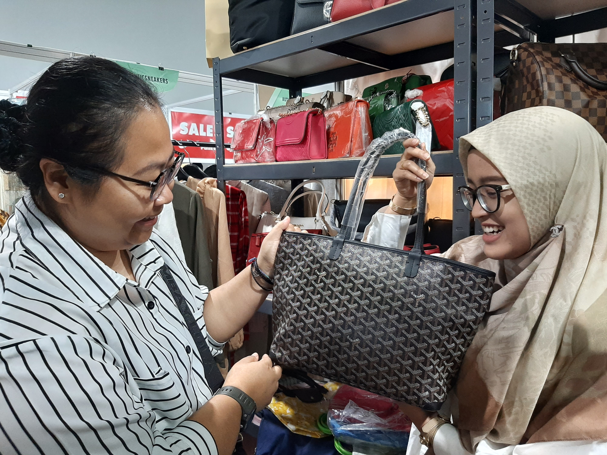 Transaksi tas branded di bazar barang preloved Surabaya. (Foto: Pita/Ngopibareng.id)