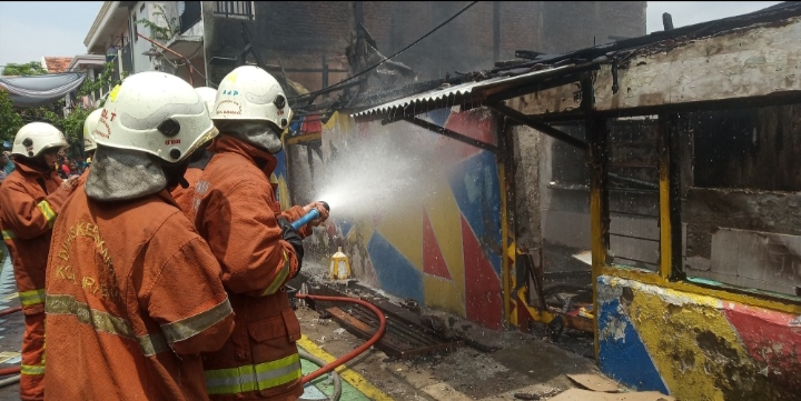 Petugas pemadam kebakaran tengah berusaha memadamkan api yang membakar rumah di Jalan Ikan Kerapu, kec. Krembangan (foto: Andhin Dwi/ngopibareng.id) 