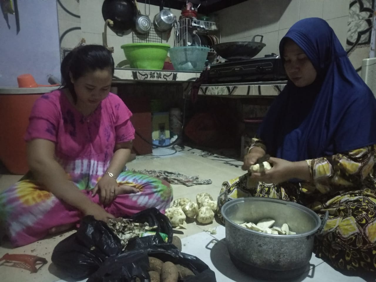 Tatik dibantu anak perempuannya, Rika memotong ketela (Foto: Rizqi Mutqiyyah/ngopibareng.id)