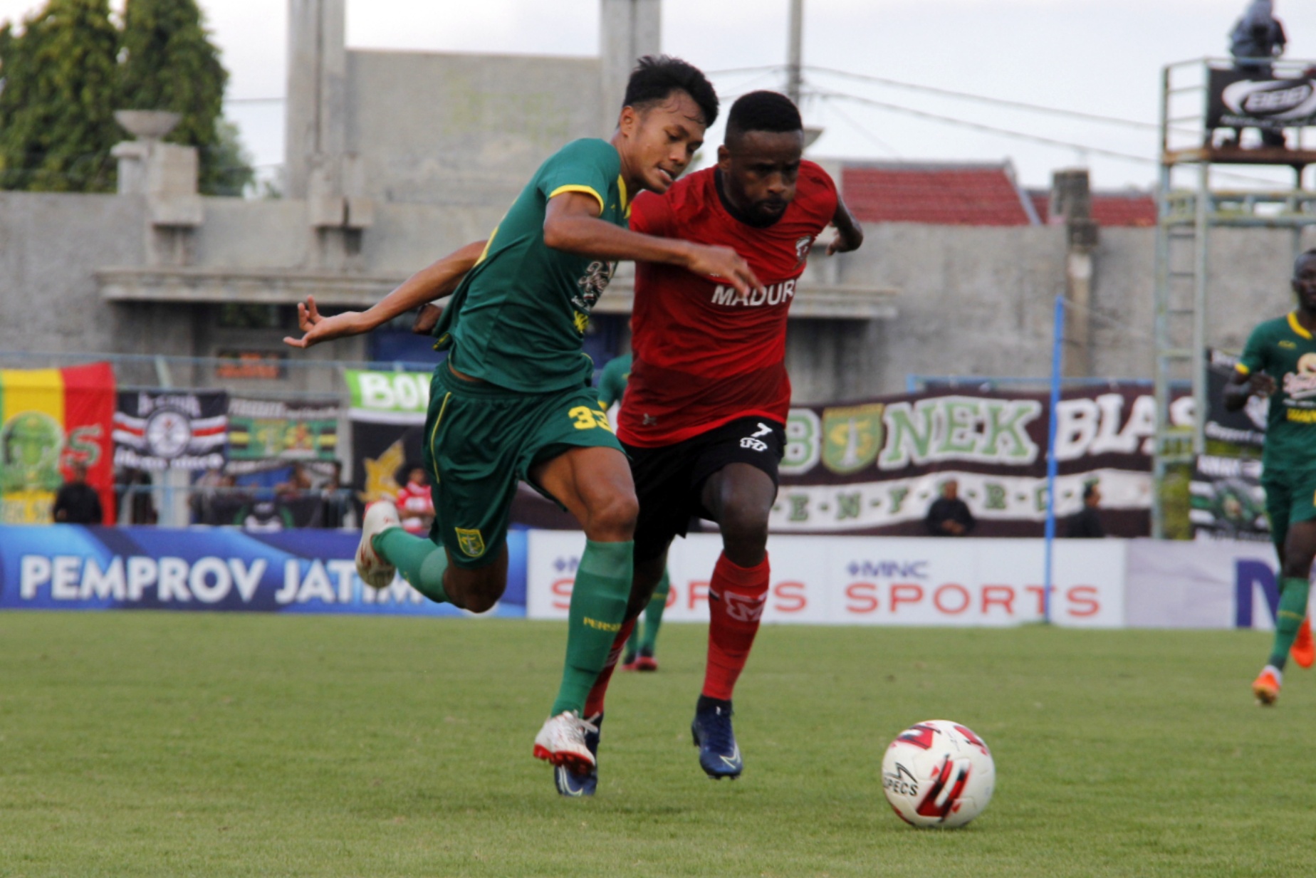 Pemain Persebaya Koko Ari beradu dengan pemain Madura United Greg Nwokolo dalam pertandingan terakhir Grup A Piala Gubernur Jatim di Stadion Gelora Bangkalan, Jumat 14 Februari 2020. (Foto: Fariz/Ngopibareng.id)