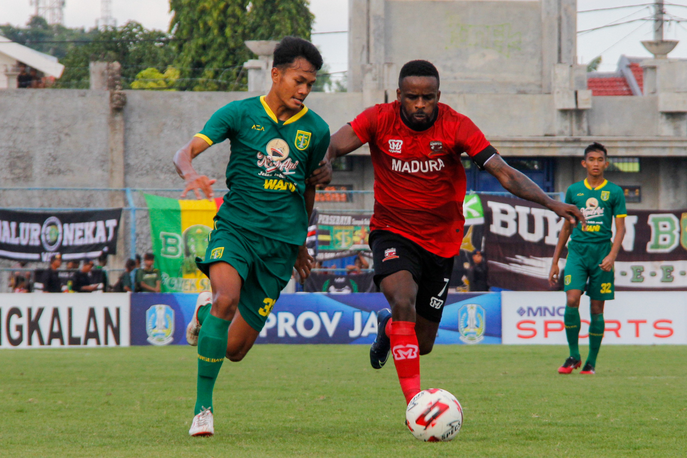 Pemain Persebaya, Koko Ari menjaga pergerakan pemain MU, Greg Nwokolo di Stadion Gelora Bangkalan, Jumat 14 Februari 2020. (Foto: Fariz Yarbo/Ngopibareng.id)