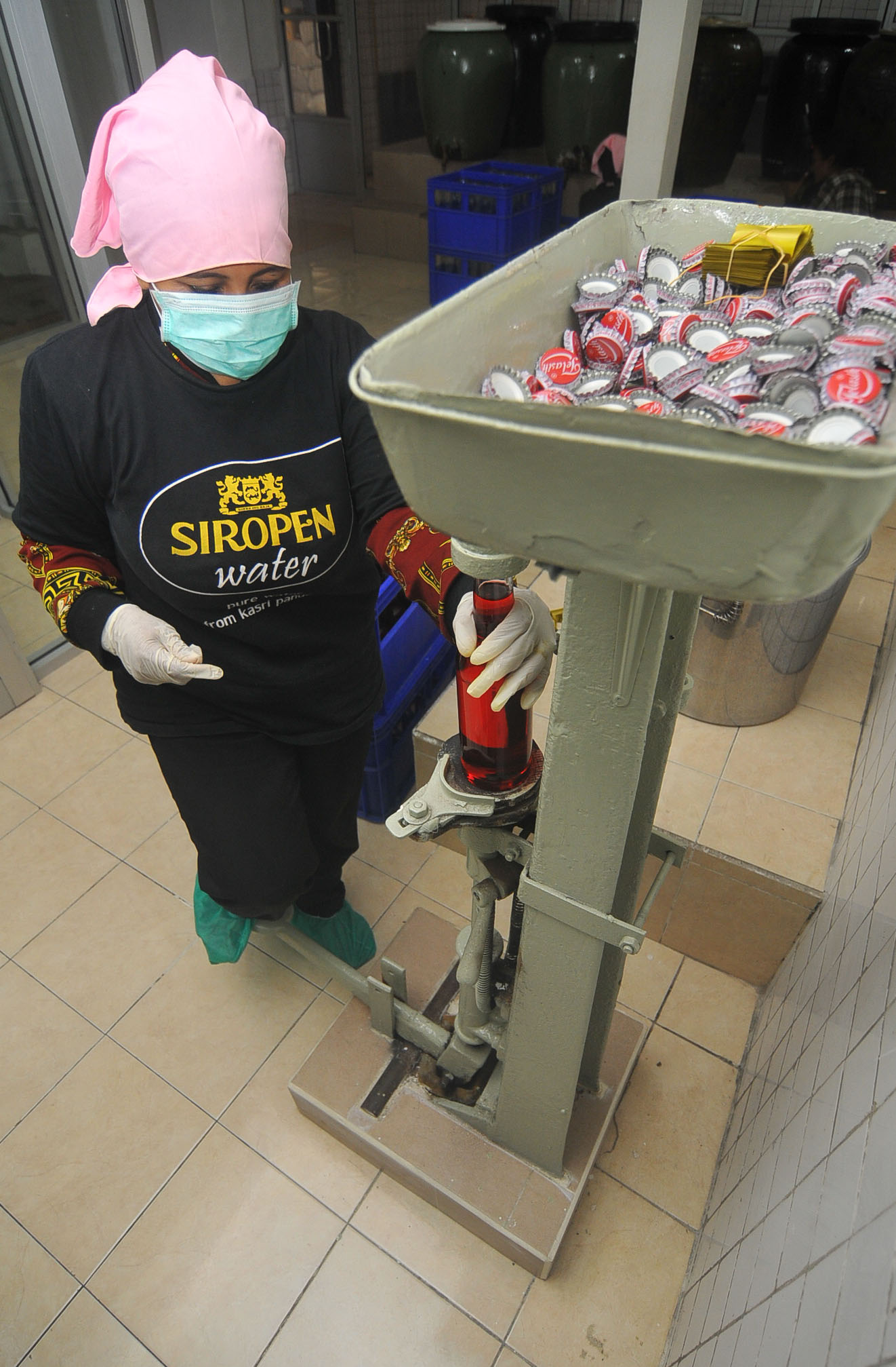 Menutup botol sirop. Sirop dikemas dalam botol. (Foto : Erfan Hazransyah/Ngopibareng.id)