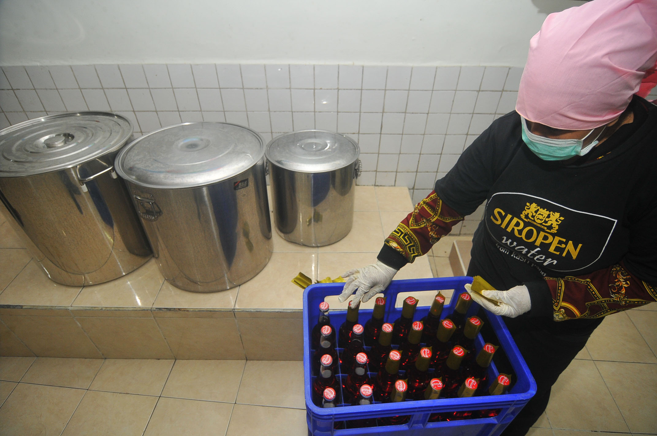 Memberi segel plastik pada botol sirop. (Foto : Erfan Hazransyah/Ngopibareng.id)