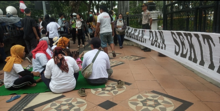 Warga Kecamatan Pesanggaran, Banyuwangi sedang beristirahat di depan kantor Gubernur Jatim (Andhi Dwi/Ngopibareng.id)