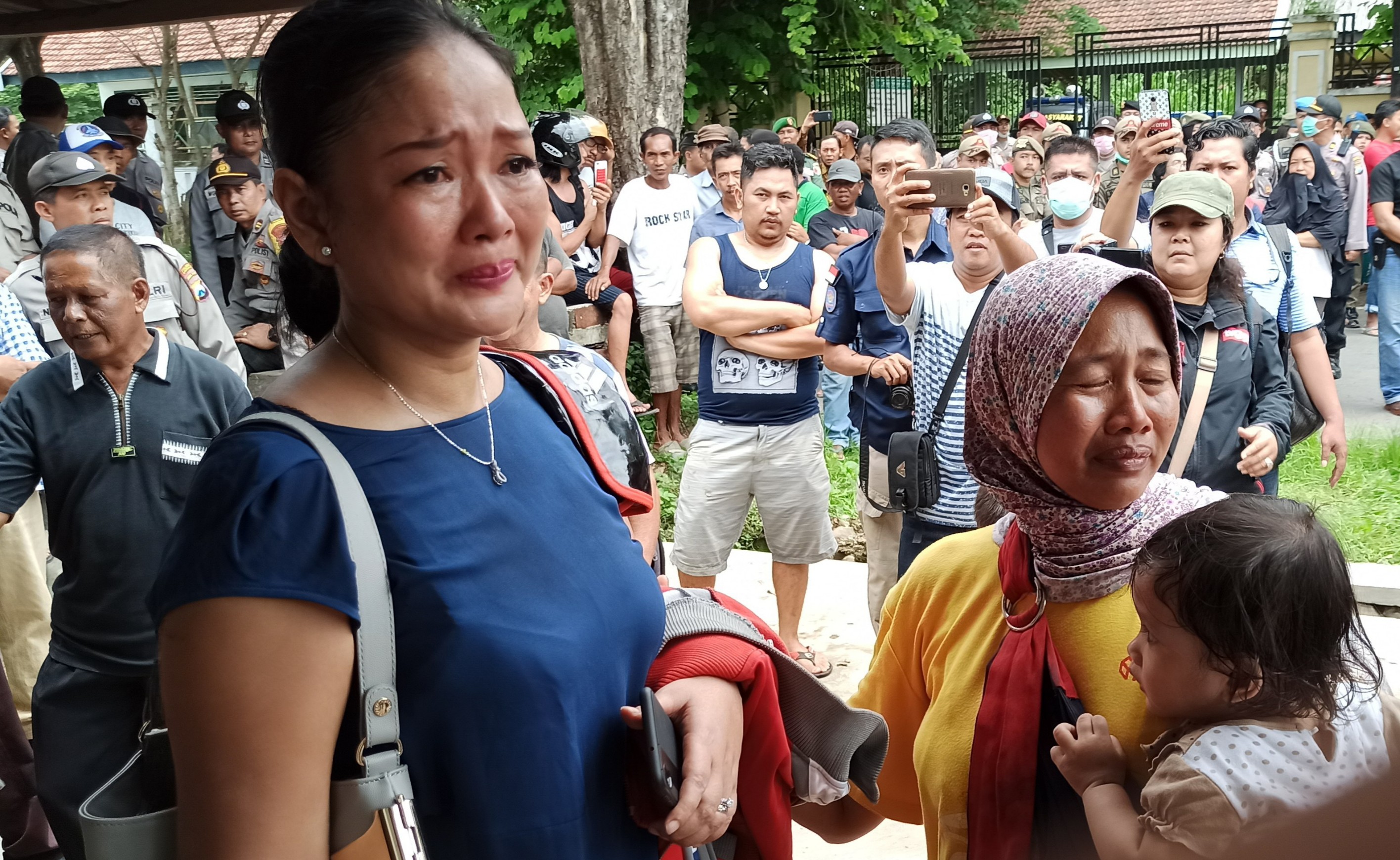 Ambar Sari (kiri) dan keluarganya tampak menangis menyaksikan proses eksekusi rumahnya (foto : Hujaini/ngopibareng.id)