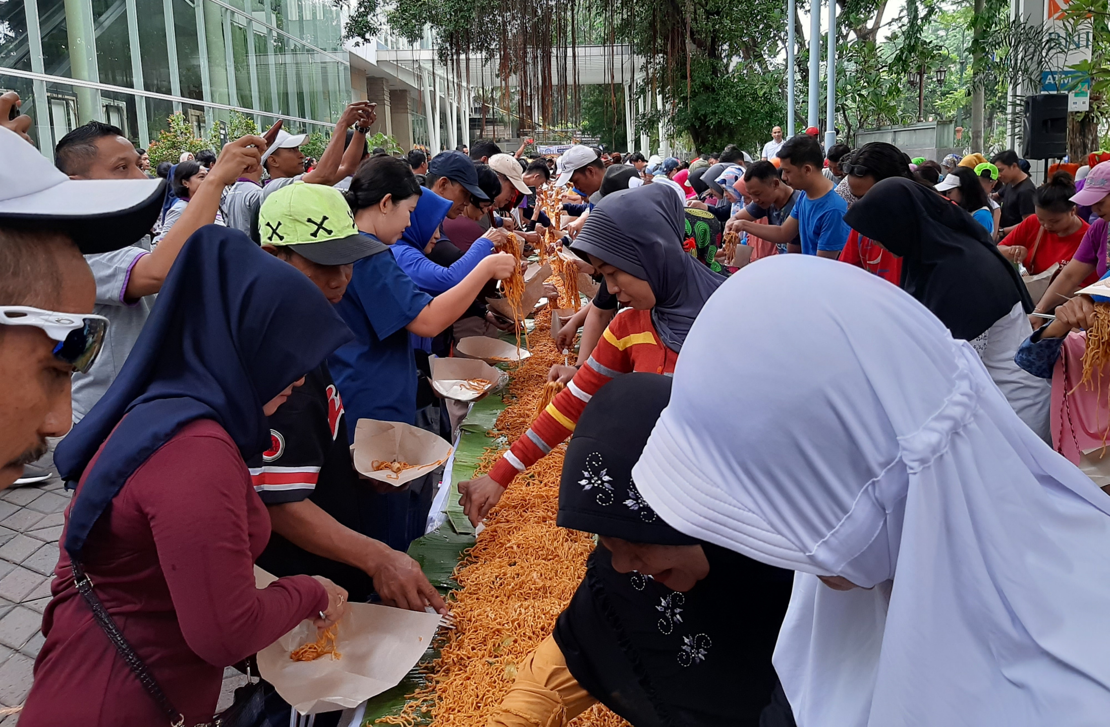 Peserta CFD saat mengambil mie seafoos sepanjang 130 meter yang disediakan cuma-cuma. (Foto:Pita Sari/Ngopibareng.id)