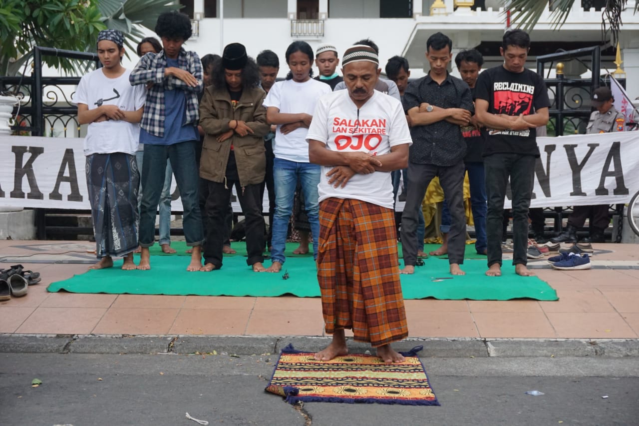 Warga Tumpang Pitu jalankan shalat di sela-sela aksi penolakan tambang emas. (Foto: Andhi Dwi/Ngopibareng.id)